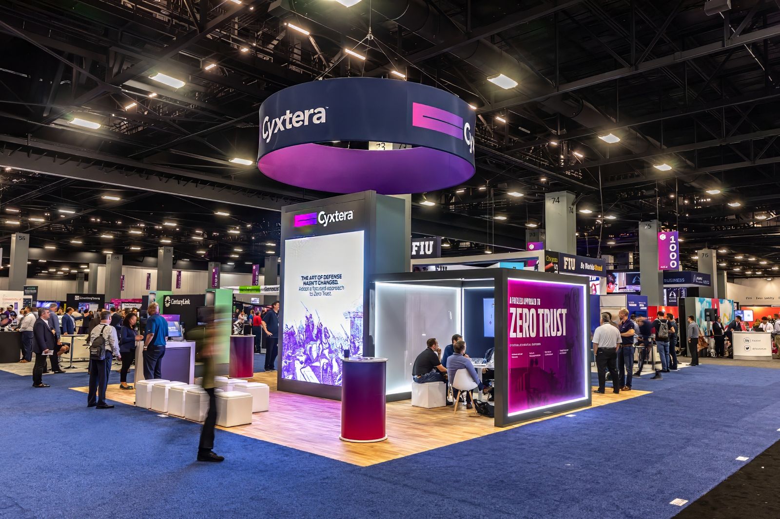 Large exhibitor booth with a hanging sign on a convention floor
