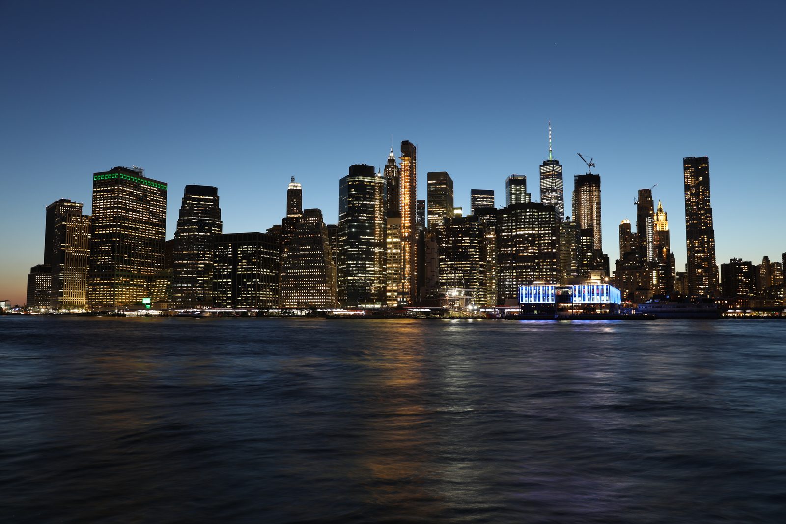 Lower Manhattan skyline at blue hour seen across the East River from Brooklyn